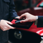 Mazda car passing between hands in car showroom